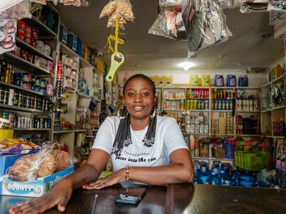 Shop owner smiling behind the counter of her store